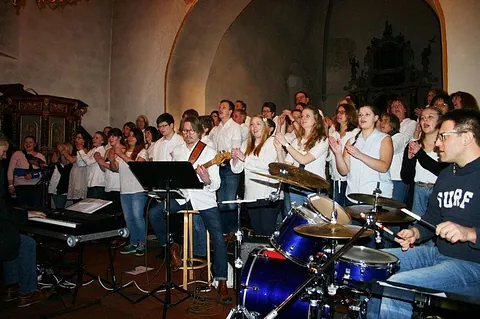 Zeitgenössische christliche Band mit Sängern und Instrumenten bei einem Auftritt.