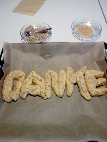 Keksteig geformt als "DANKE" auf Backblech mit Streuseln.