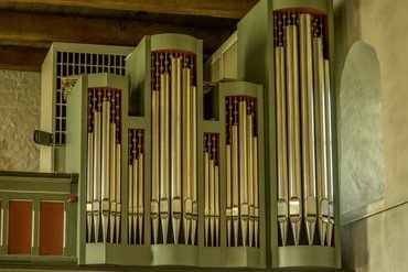 Kirchenorgelpfeifen in verschiedenen Größen mit dekorativen Gehäusedetails.